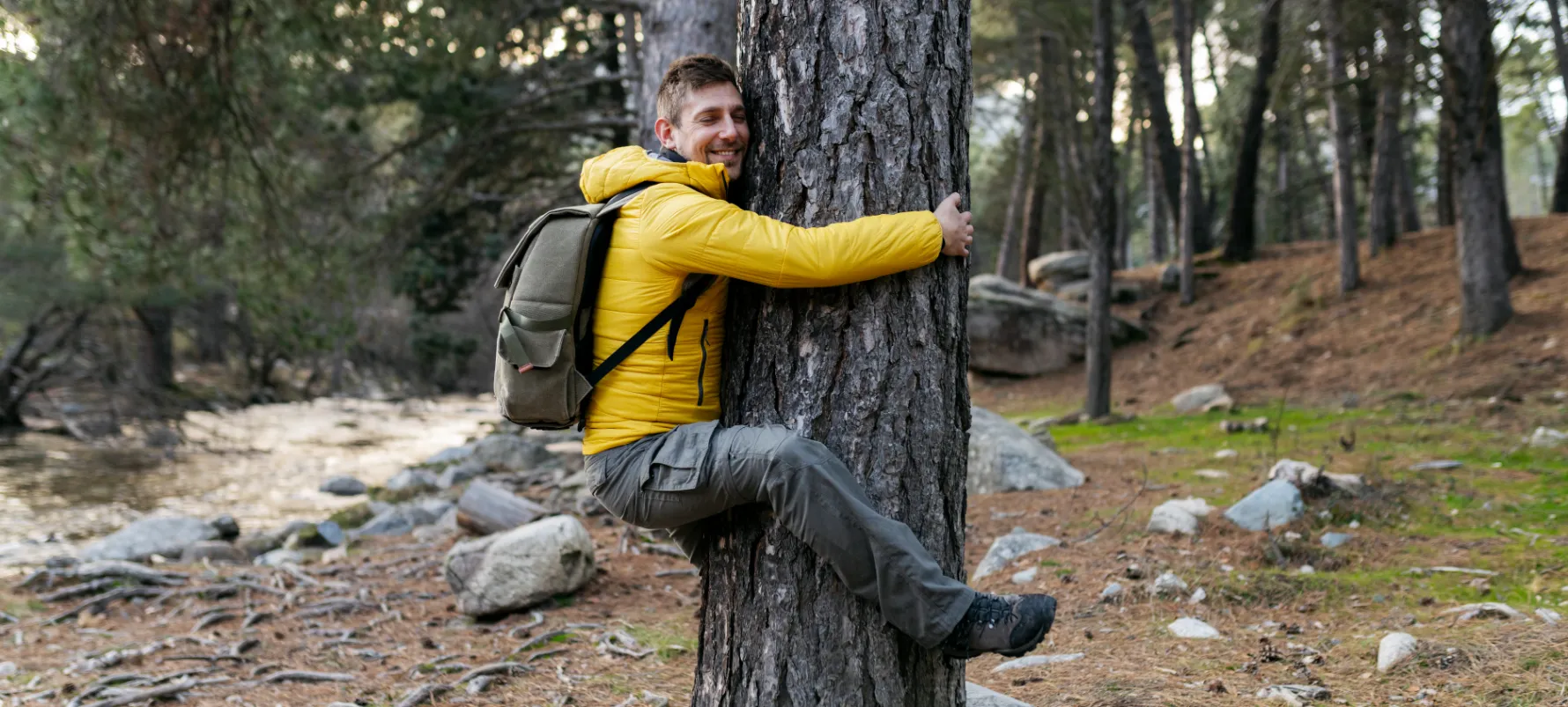 Biophilic Interior Design Fact- Man hugging tree in Nature.